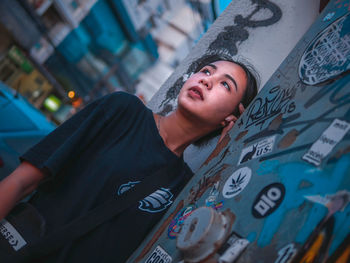 Low angle portrait of man standing on graffiti