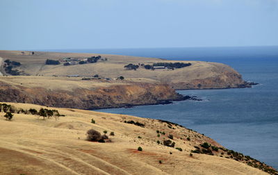 View of sea by mountains against clear sky