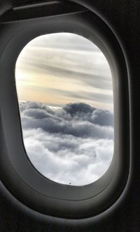 View of cloudy sky seen through airplane window