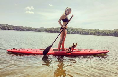 Woman paddleboarding with dog