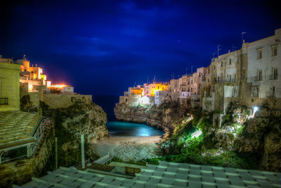 Illuminated city against sky at night