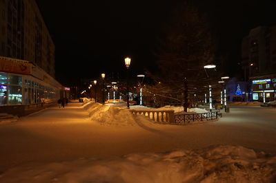 Illuminated street in city at night