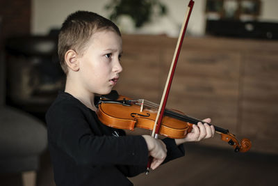 Boy playing violin at home