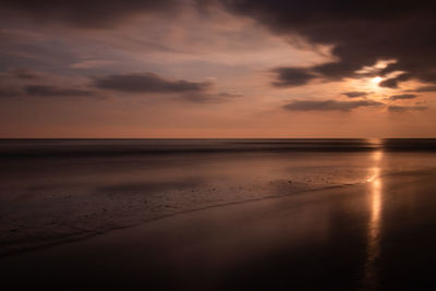 Scenic view of beach against sky during sunset