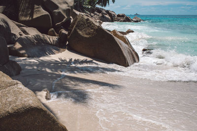 Rock formation on beach against sky