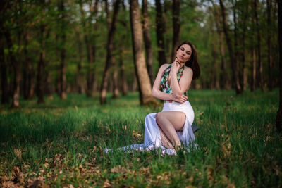 Full length of woman sitting on field