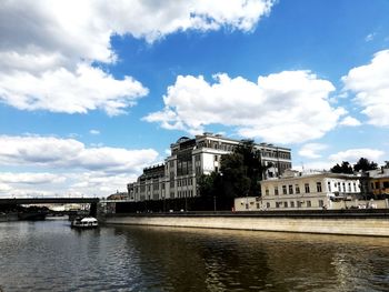 Arch bridge over river against buildings in city