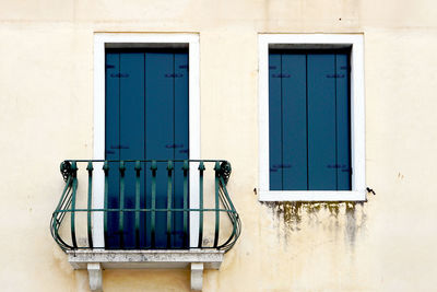 Door with balcony and window on creme wall building in venice, italy