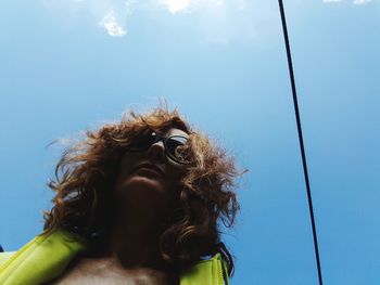 Low angle portrait of woman wearing sunglasses against sky
