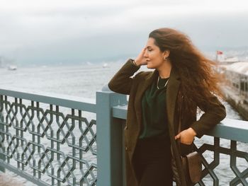 Young woman looking at sea against sky