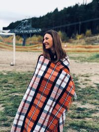 Portrait of smiling young woman standing on field