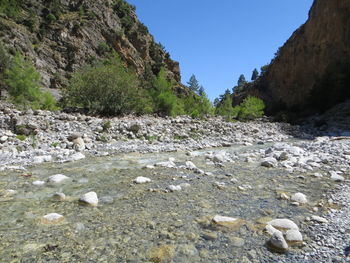 Surface level of rocky shore against clear sky