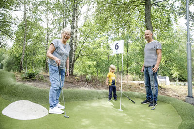 Family playing mini golf