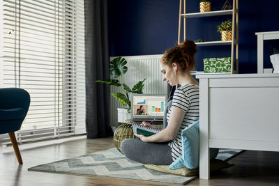 Woman using phone while sitting on table