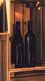 Close-up of beer bottles on wooden shelf