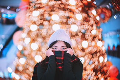 Portrait of woman in illuminated park during winter