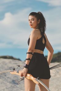 Portrait of young woman standing at beach