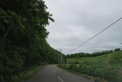 Road amidst trees against sky