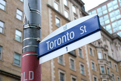 Low angle view of information sign against buildings in city