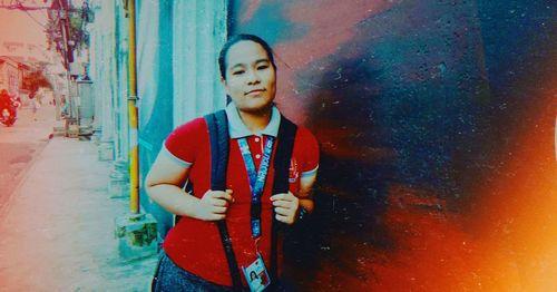 Full length of cute girl standing against wall