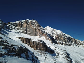 Scenic view of snowcapped mountains against clear blue sky