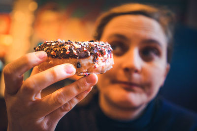 Woman holding dessert while sitting at restaurant