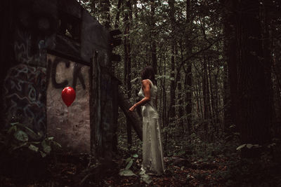 Man standing on balloons in forest