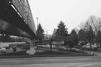 Cars on bridge in city against clear sky