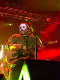 Man playing guitar on illuminated stage