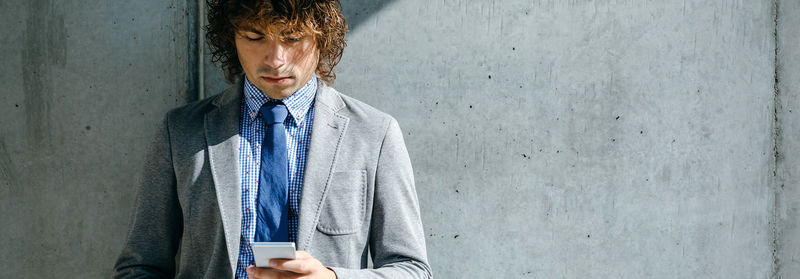 Man looking at camera while standing against wall