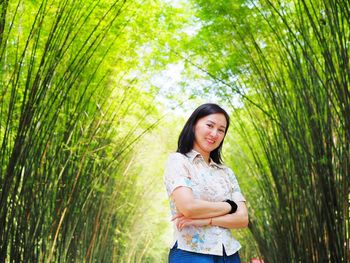 Smiling woman standing by plants