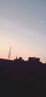 Silhouette buildings against sky at dusk