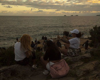 People photographing at beach against sky