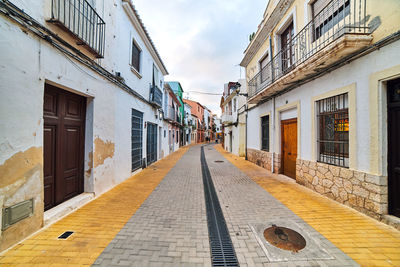 Empty alley amidst buildings in town