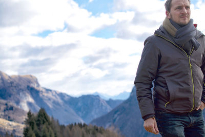 Low angle view of man standing on mountain against sky