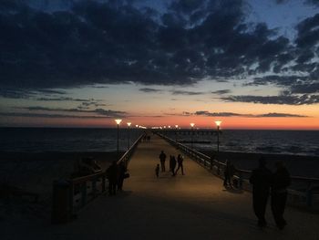 Pier over sea against sky during sunset