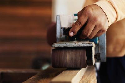 Close-up of man working with equipment on wood