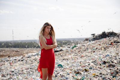 Portrait of young woman walking on garbage