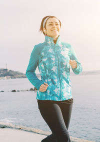 Woman running on promenade against sky