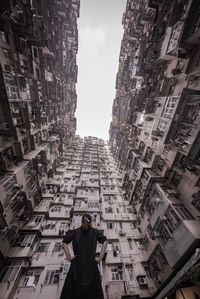 Low angle view of woman standing amidst buildings in city