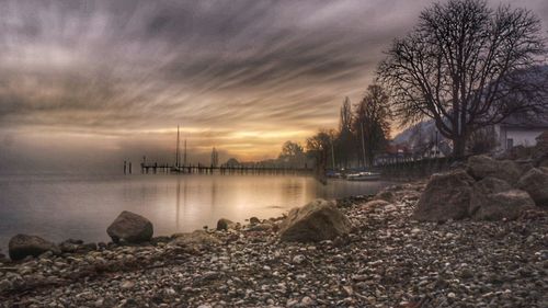 Scenic view of river against sky at sunset