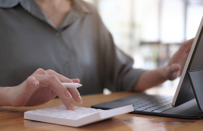 Midsection of person using laptop on table