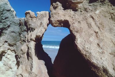 Rock formations by sea against sky