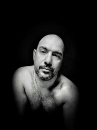 Portrait of young man against black background