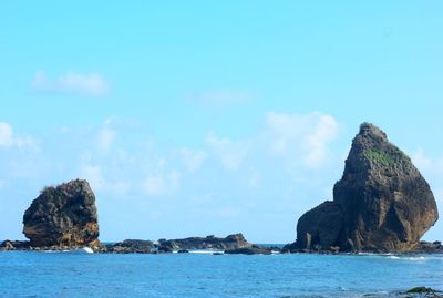 Rock formations in sea against sky