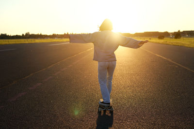 Rear view of woman walking on road