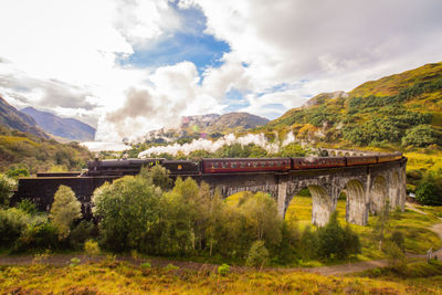 Bridge over mountains against sky