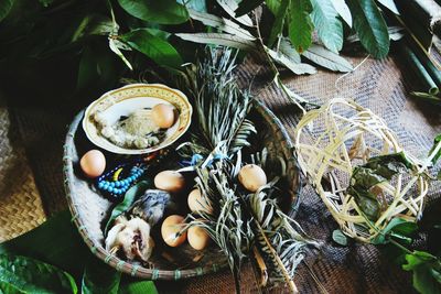 High angle view of eggs with plants in wicker basket on table