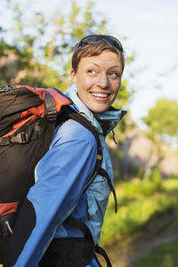 Female hiker with backpack looking over shoulder outdoors