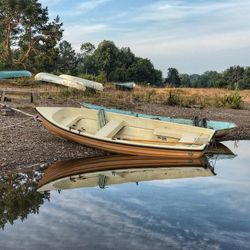 Boats moored in lake against sky